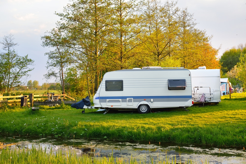 Caravan by a pond during autumn